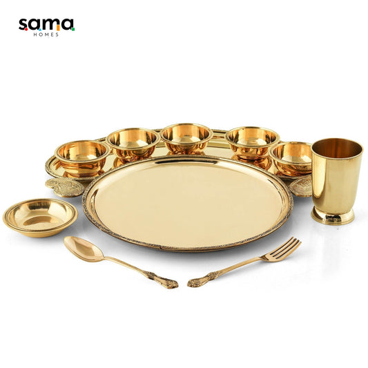 Brass dinner plates, bowls, cups, and cutlery on a table setting